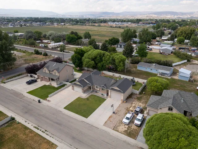 Residential property featuring a two-story home with an attached garage, a single-story home with an attached garage, and a single-story light blue home