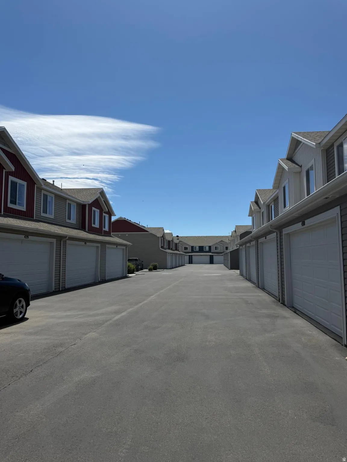 Paved drive aisle framed by rows of attached garages