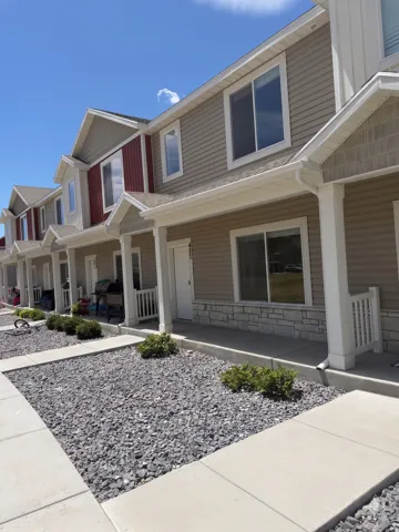 Multi-story townhome with durable siding and stone accents