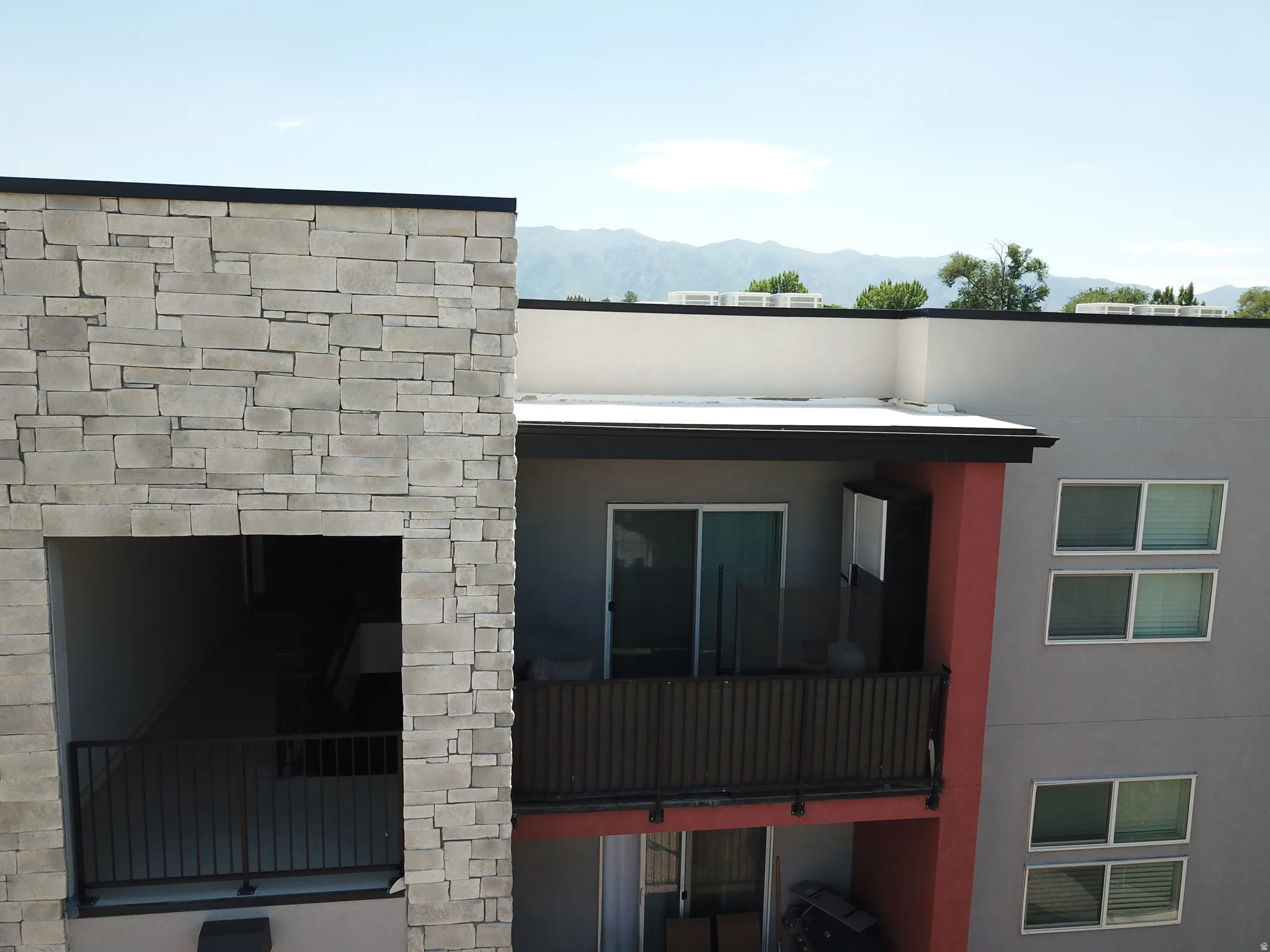 Modern exterior with stone accents and a private balcony