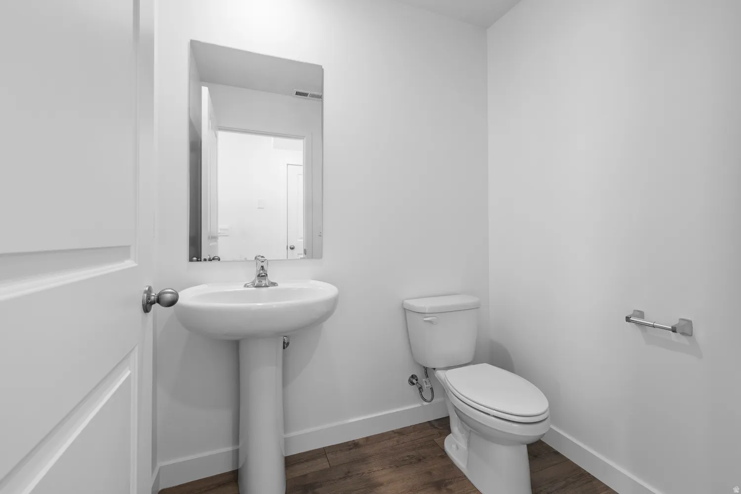 Pedestal sink with chrome faucet and rectangular mirror