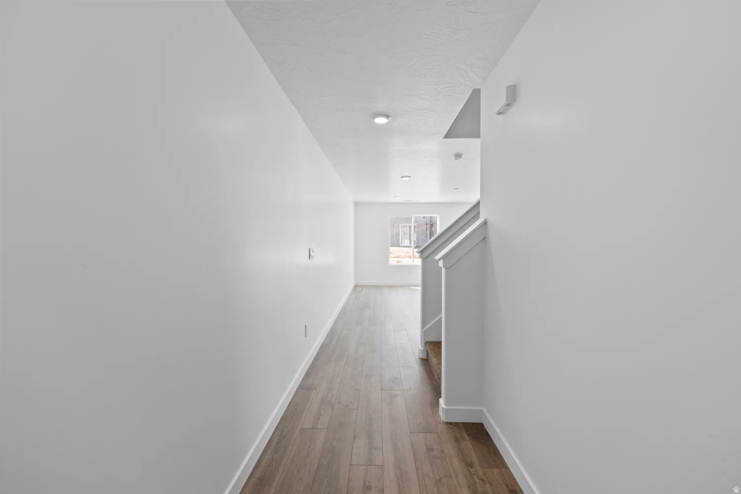 Entryway featuring wood-finish flooring, white walls, and recessed lighting