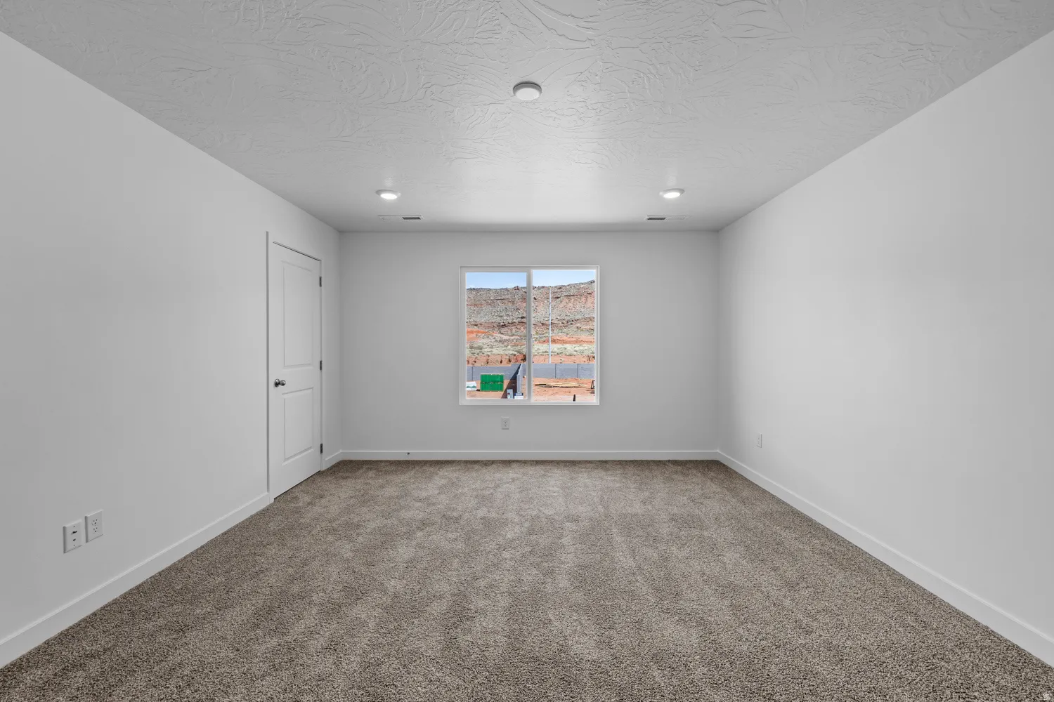 Bright interior space featuring neutral wall finishes and a window with mountain scenery