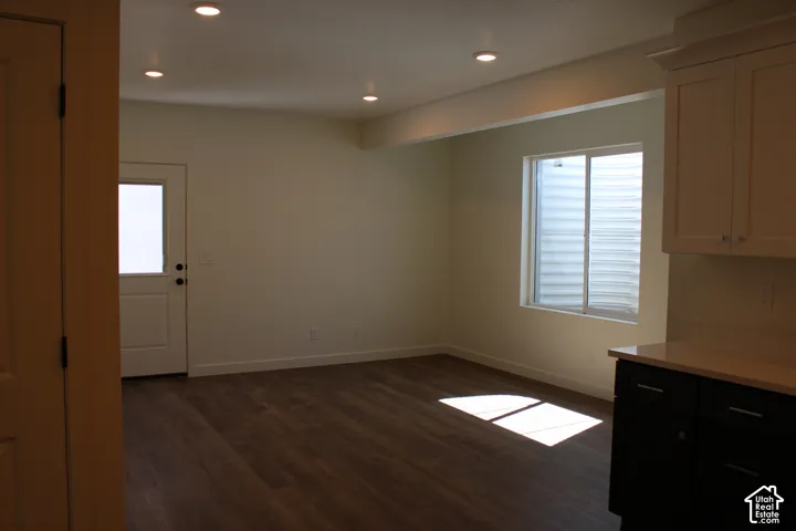 ADU Open concept room featuring wood-finish flooring, recessed lighting, and a white paneled door with glass insert