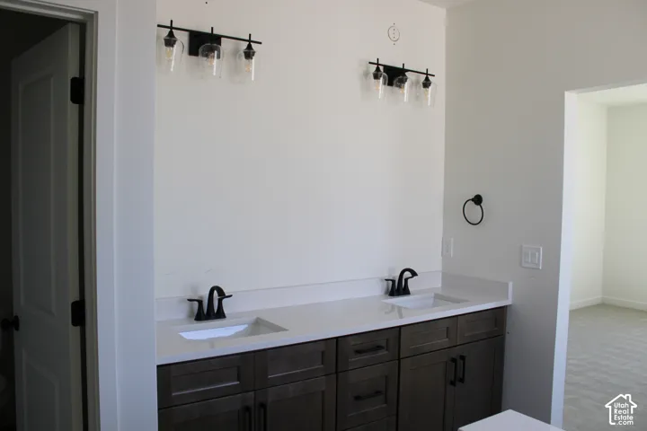 Dual vanity with white countertops, integrated sinks, and matte black hardware
