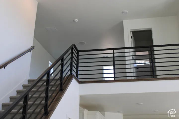 Staircase featuring dark wood-finish handrails and black metal horizontal balusters