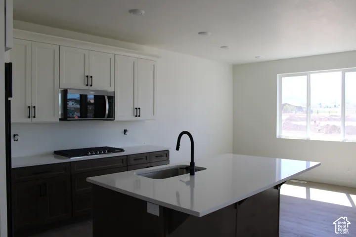 Contemporary kitchen featuring a large island with an integrated sink and gooseneck faucet