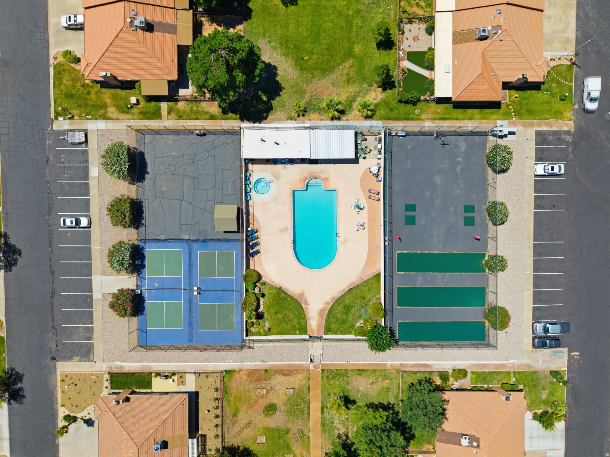 Central amenity area featuring a curvilinear swimming pool, adjacent spa, and surrounding hardscaping