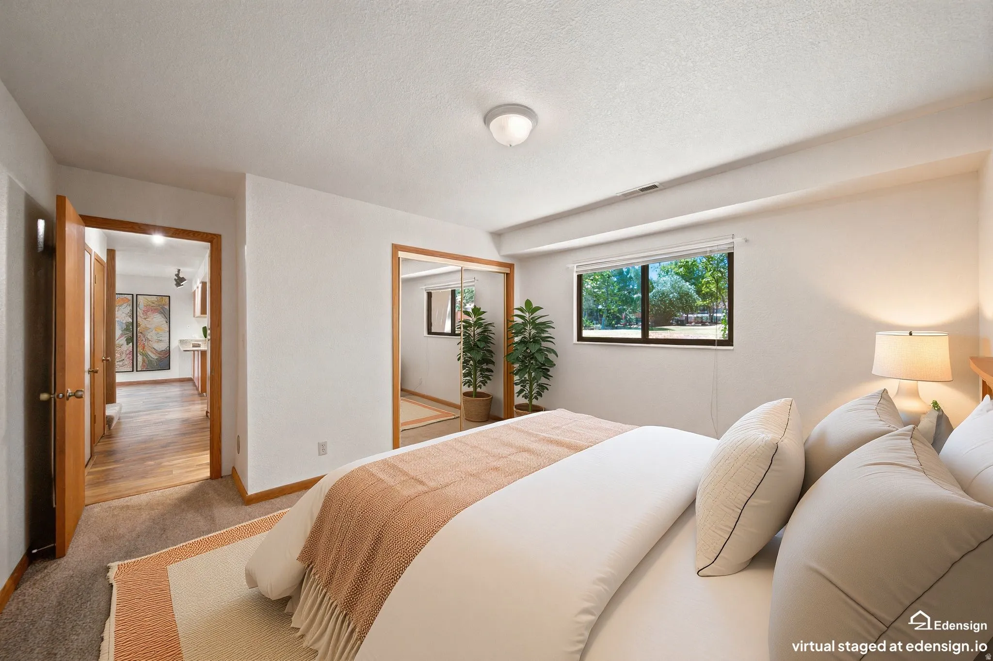 Bedroom featuring a large window, carpeted flooring, and a mirrored closet