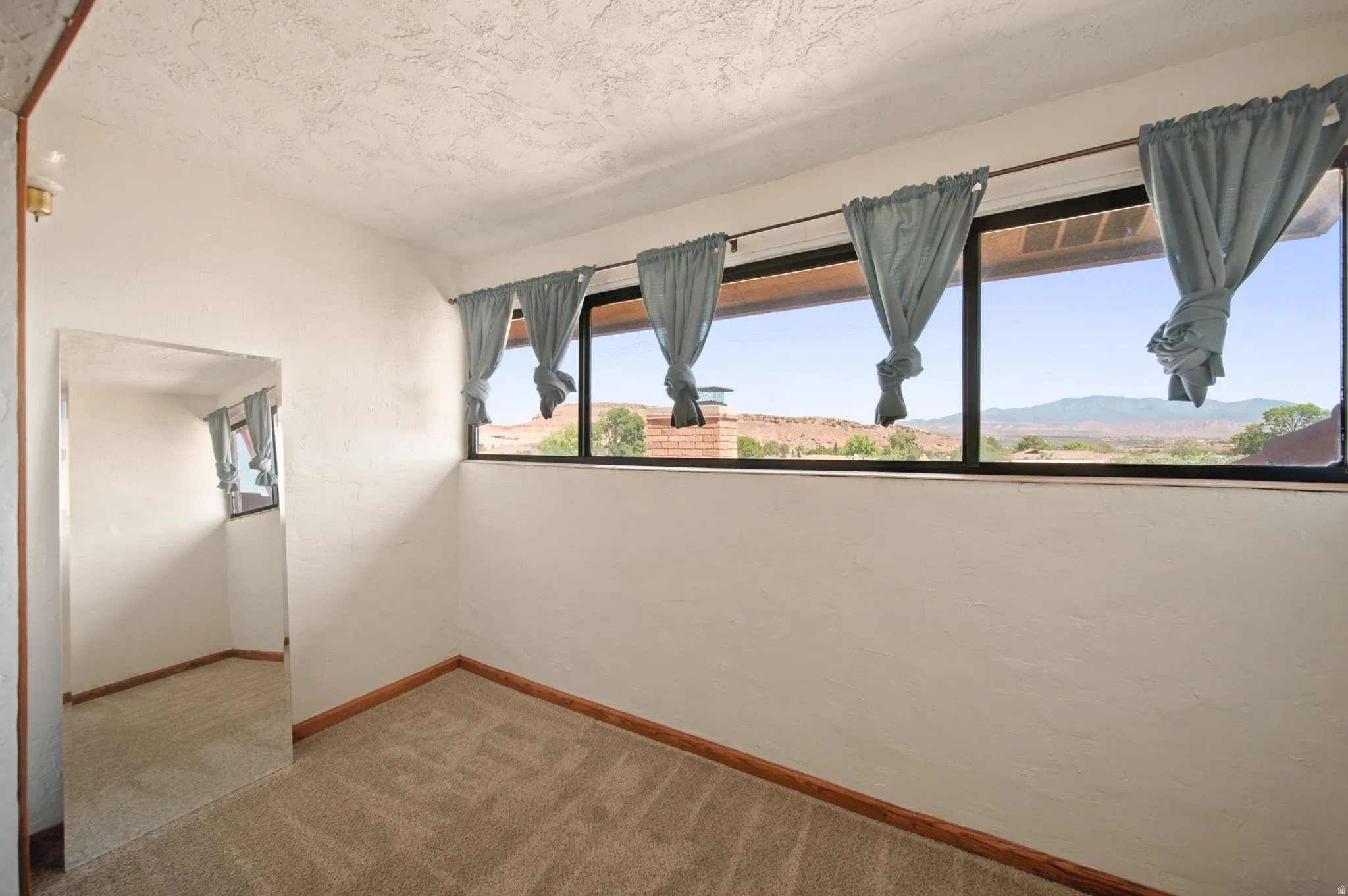 Wall-to-wall carpeting and wood trim create a neutral palette for this room