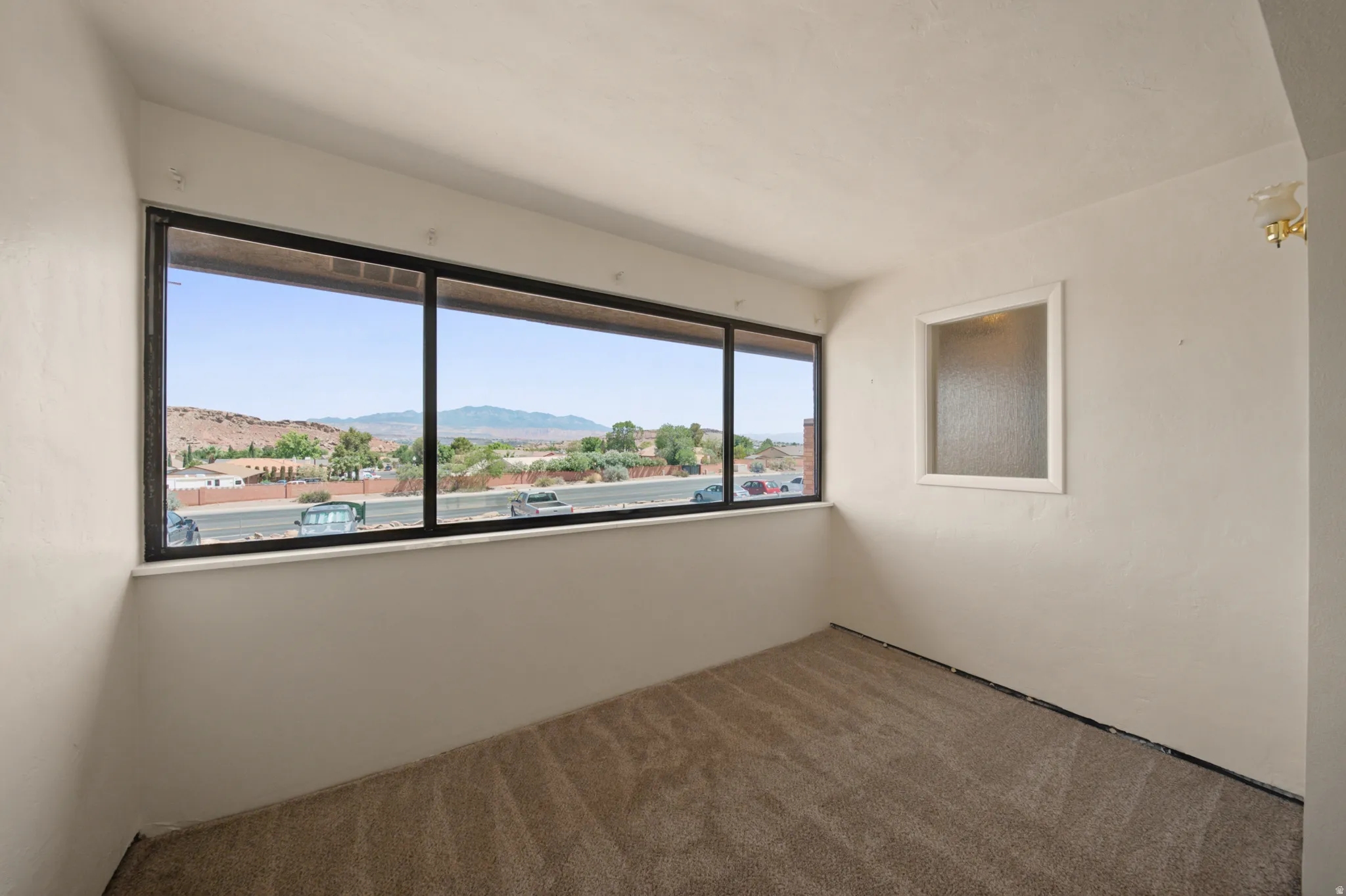 Wall-to-wall carpeting and a wide window offering mountain scenery