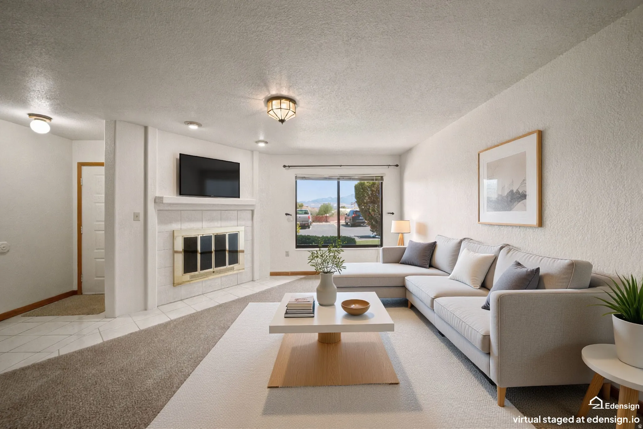 Living area featuring a fireplace with a tiled surround and mantel, recessed lighting, and a window offering outdoor views