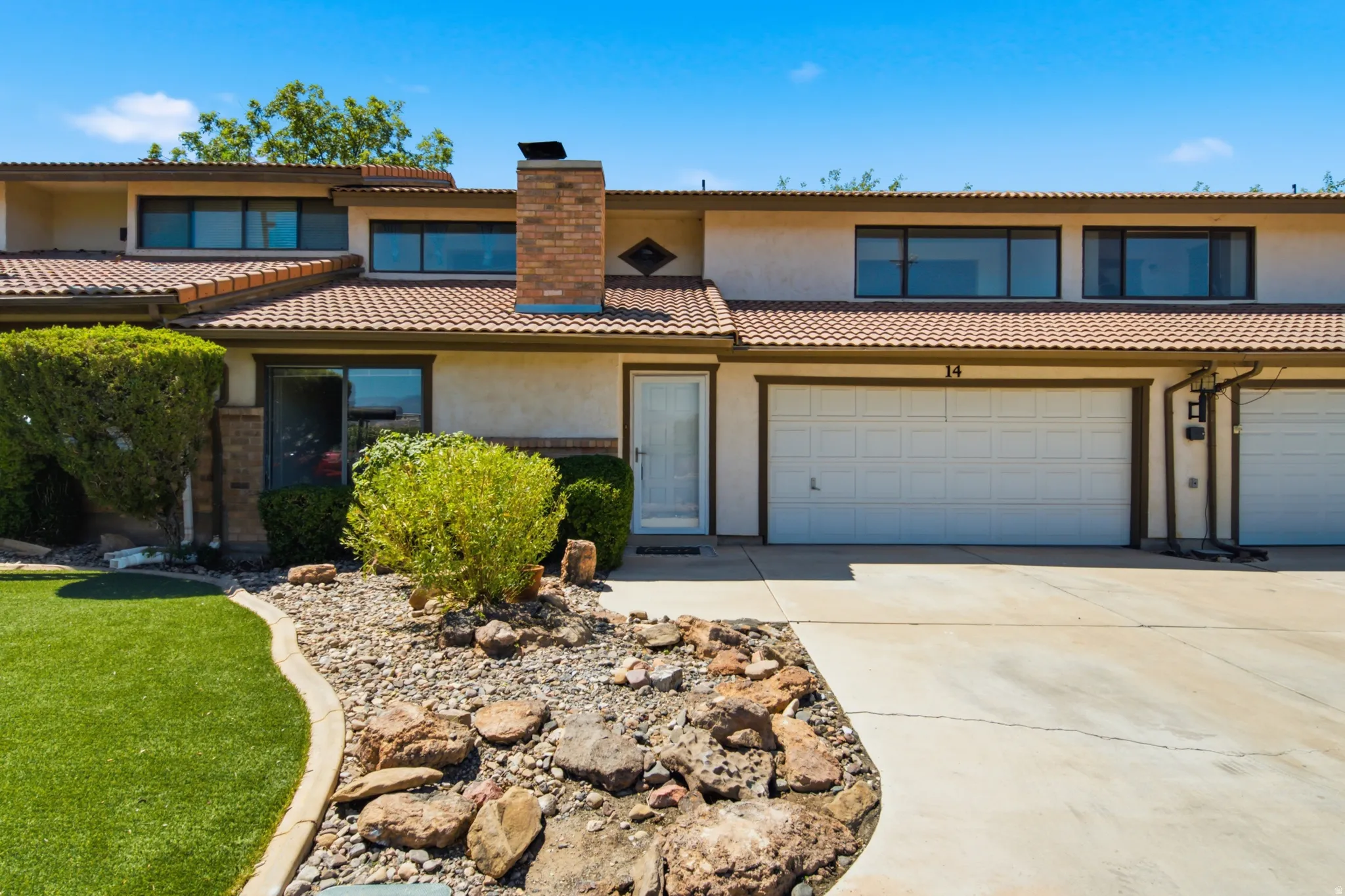 Multi-level stucco exterior with a tile roof and integrated garage