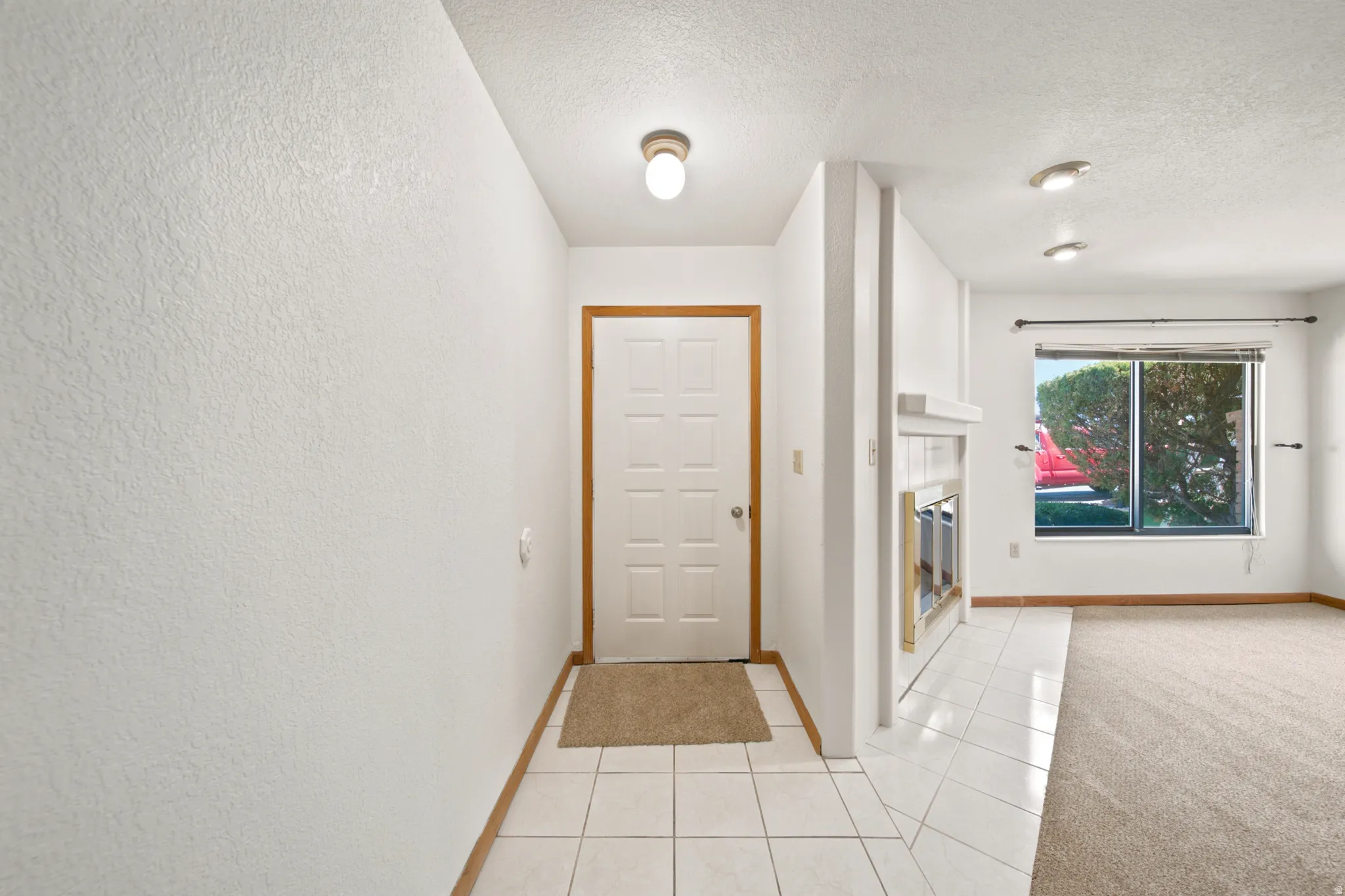 Entryway featuring a white paneled door with wood trim, ceramic tile flooring, and a flush-mount ceiling light