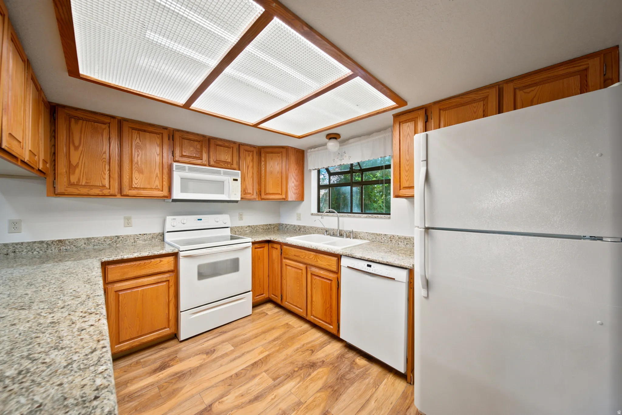 Kitchen featuring wood-finish flooring and oak cabinetry