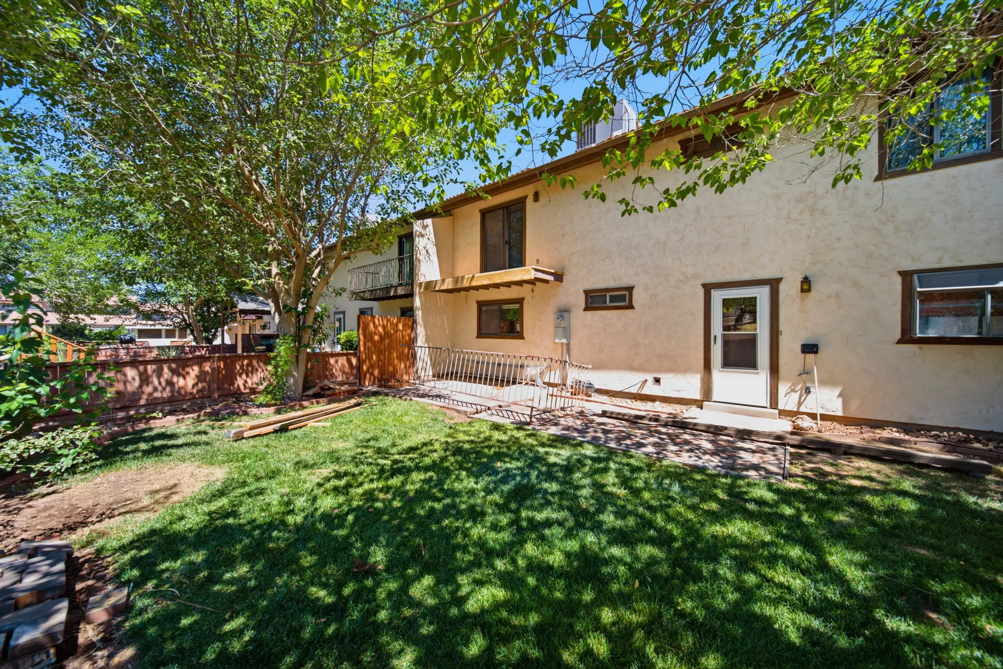 Rear exterior featuring a stucco finish, multiple windows, and a white entry door