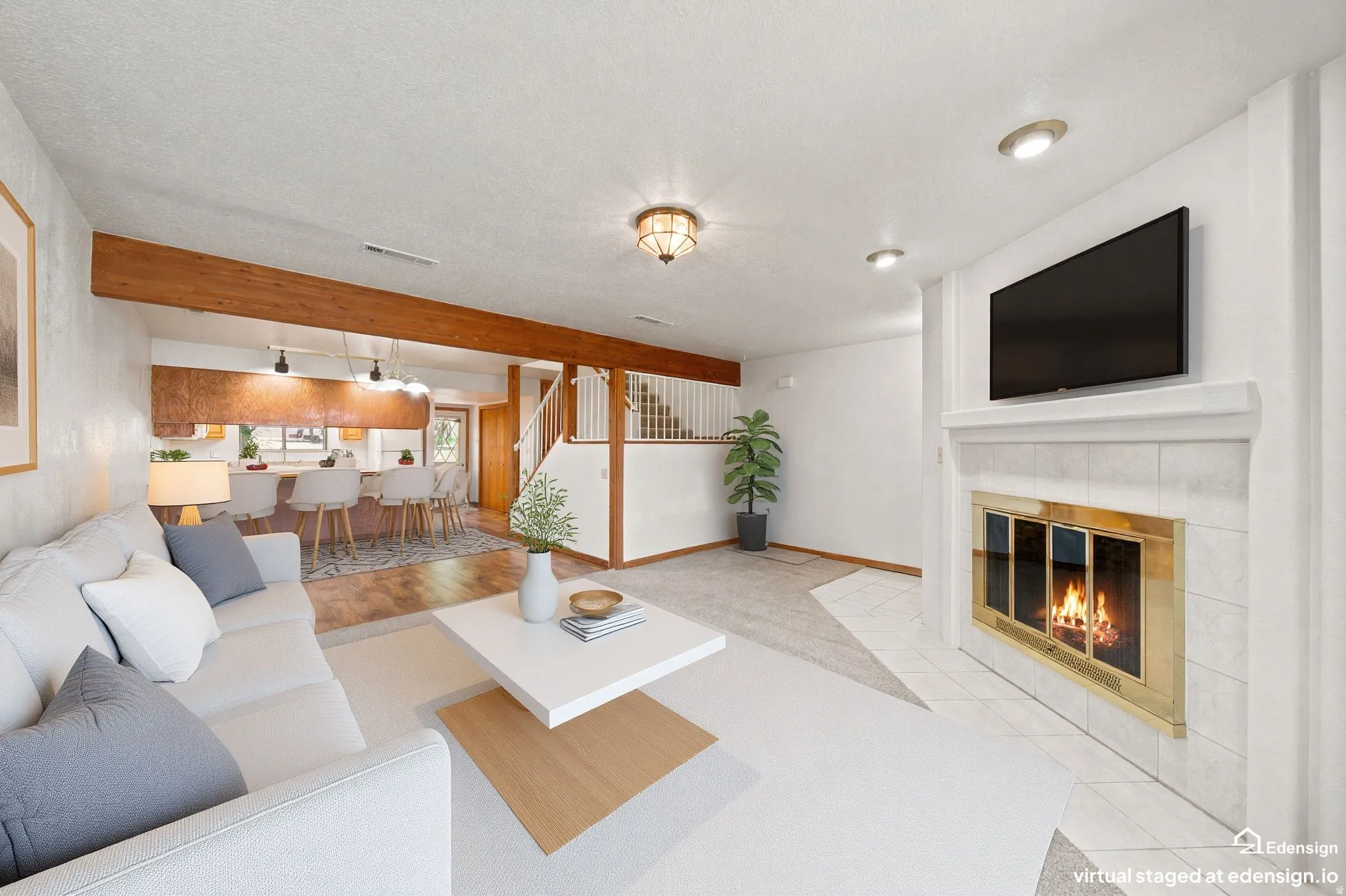 Living space featuring a tiled fireplace with a brass-trimmed insert, recessed lighting, and a wood-finish beam accent