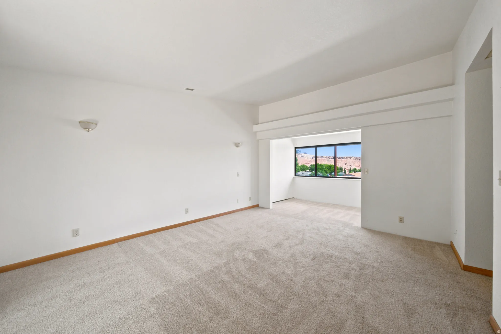 Spacious interior featuring neutral carpet flooring and white walls