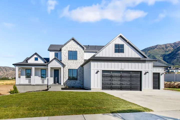 Contemporary two-story residence featuring a mixed material exterior of stone and vertical siding
