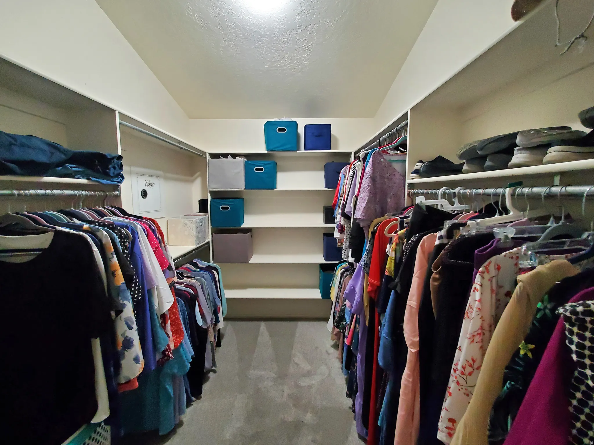 Spacious walk-in closet featuring extensive built-in shelving, multiple hanging rods, and recessed ceiling lighting