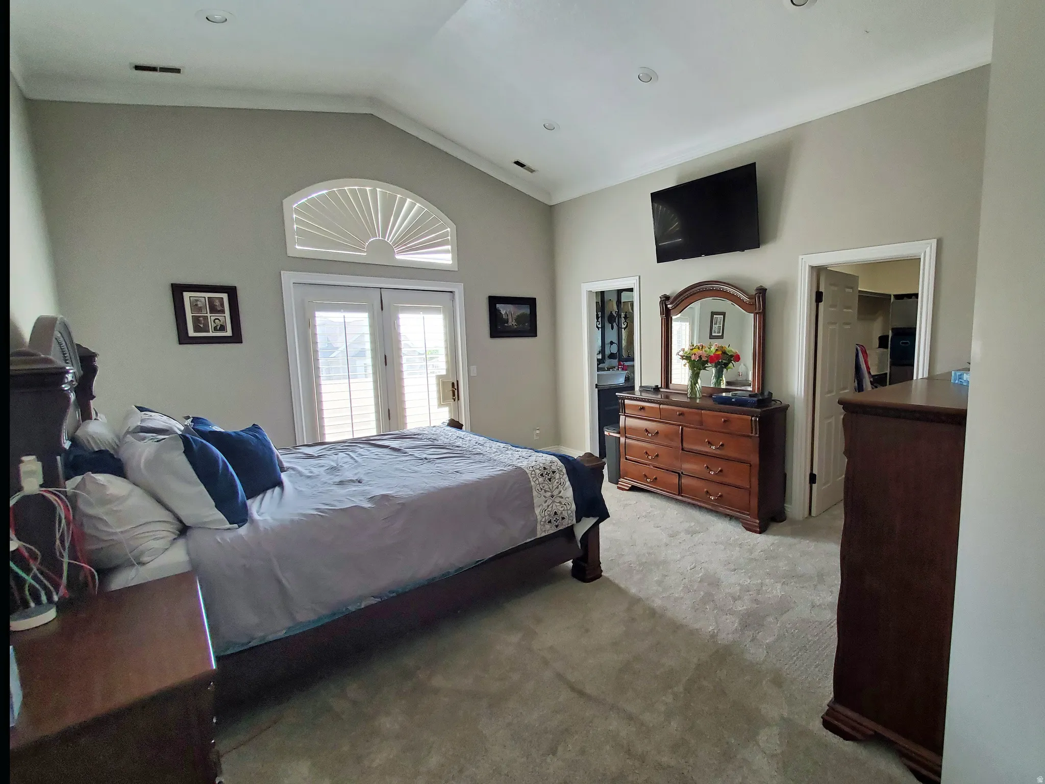 Vaulted ceiling bedroom featuring a transom window, French doors, recessed lighting, and carpet flooring