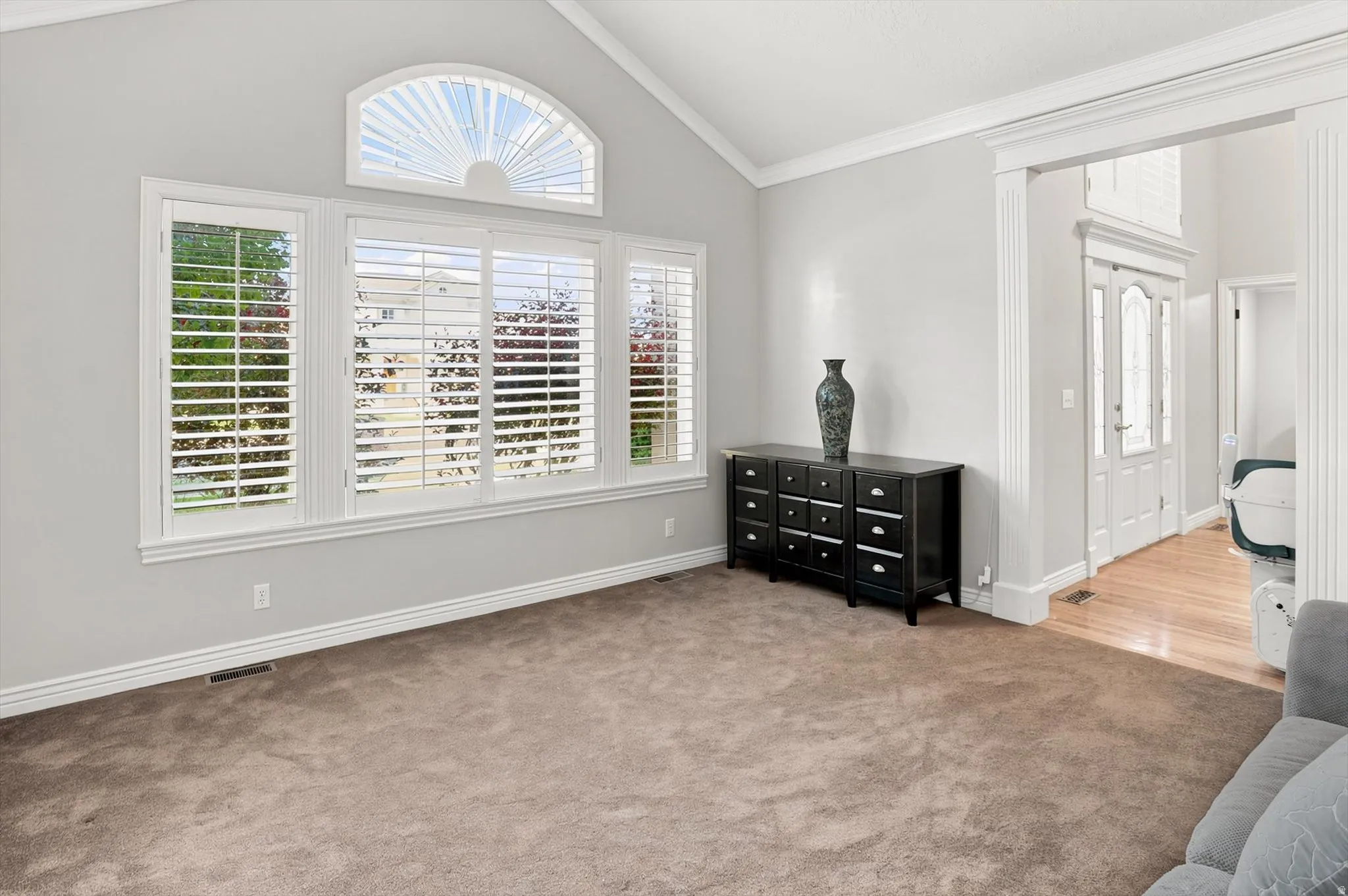 Vaulted ceiling featuring a large arched window with custom shutters