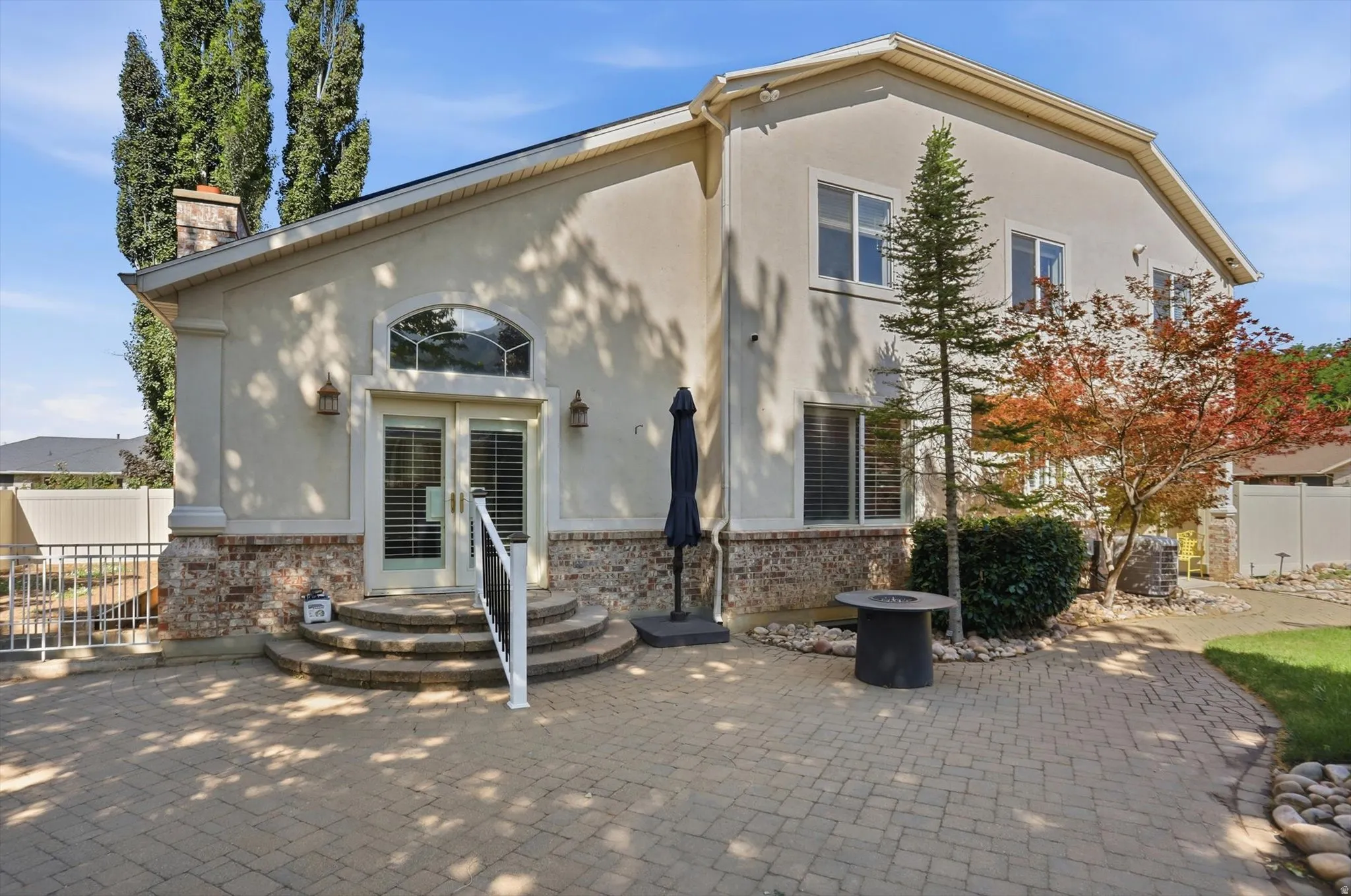 Stucco exterior with a brick base and arched transom windows