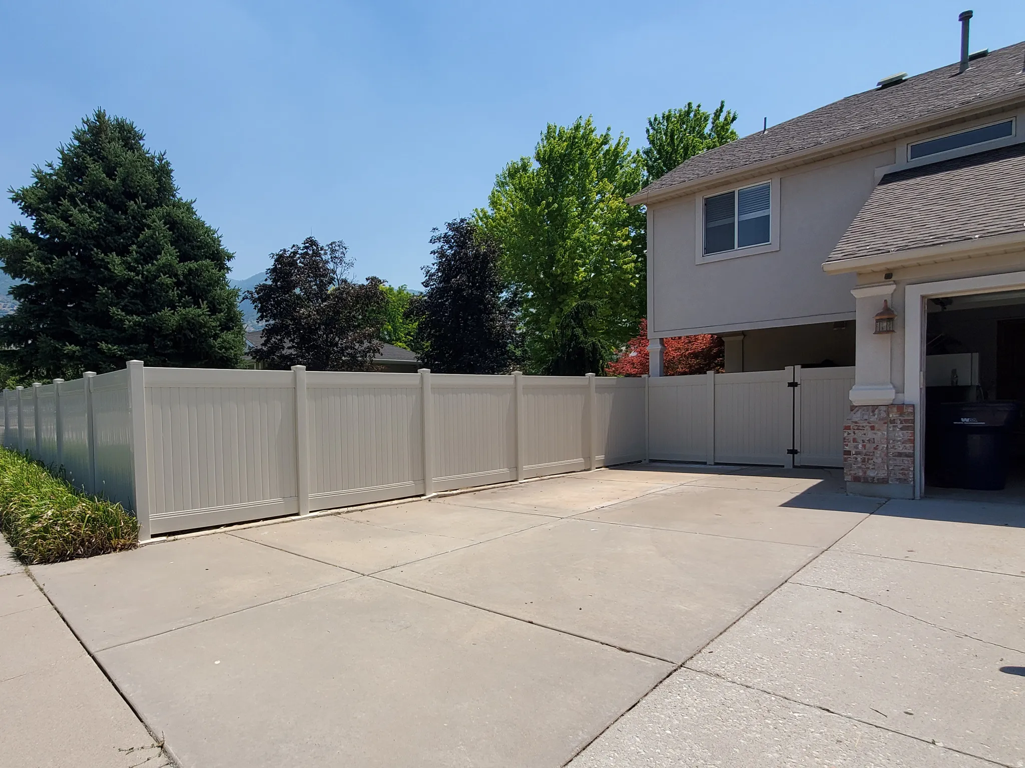 Concrete driveway with a full privacy fence