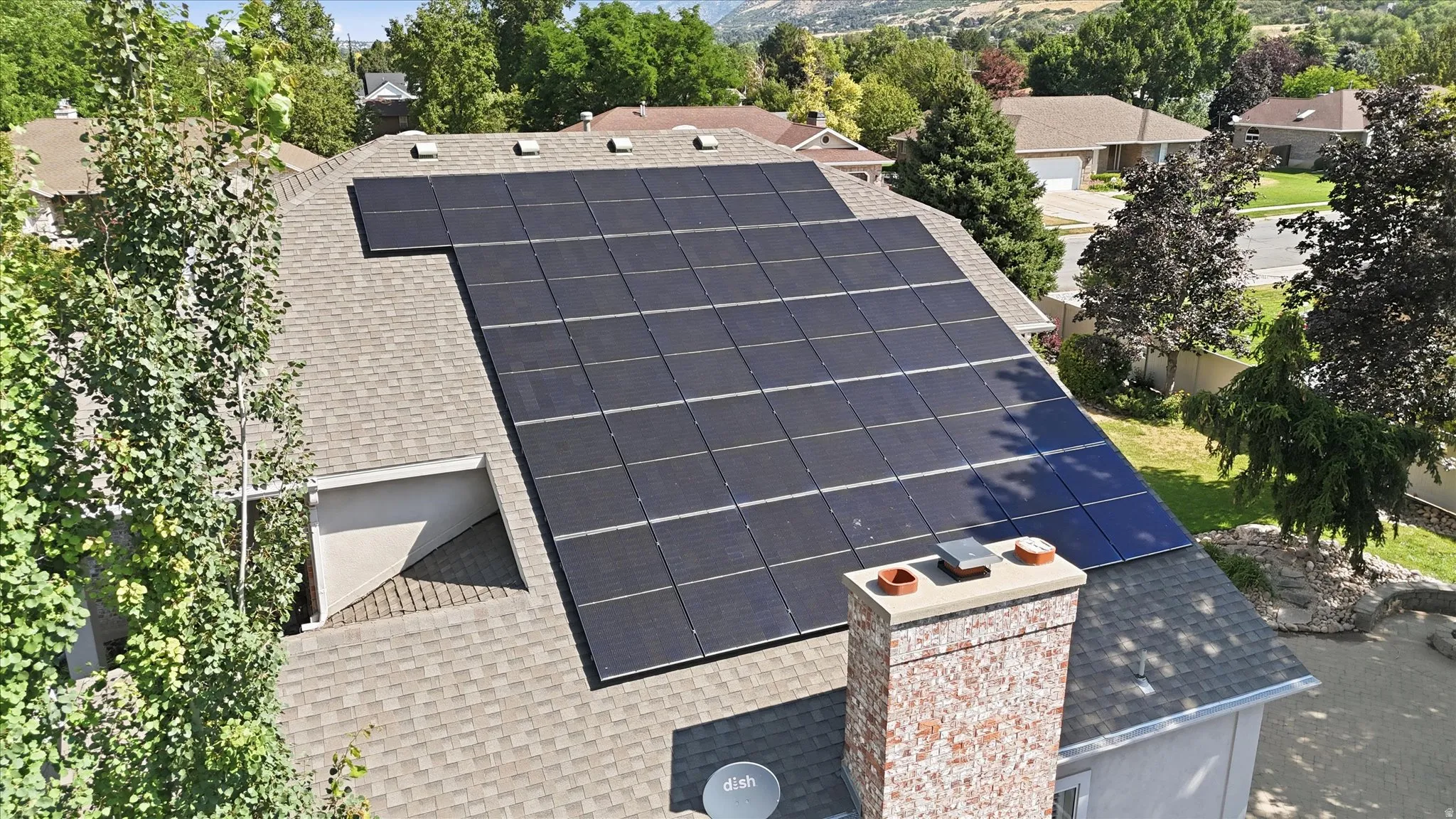Asphalt shingle roof featuring an extensive solar panel array