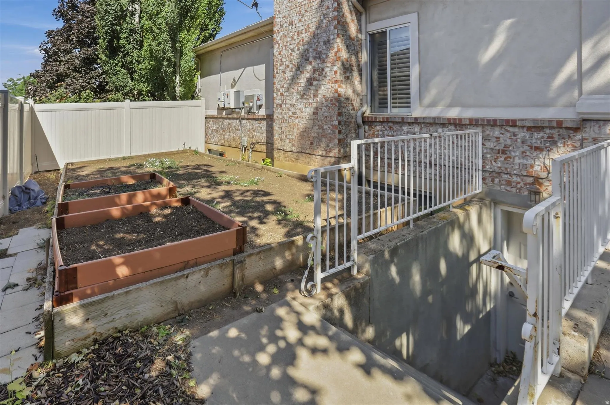 Concrete steps with white metal railings provide exterior access to a lower level