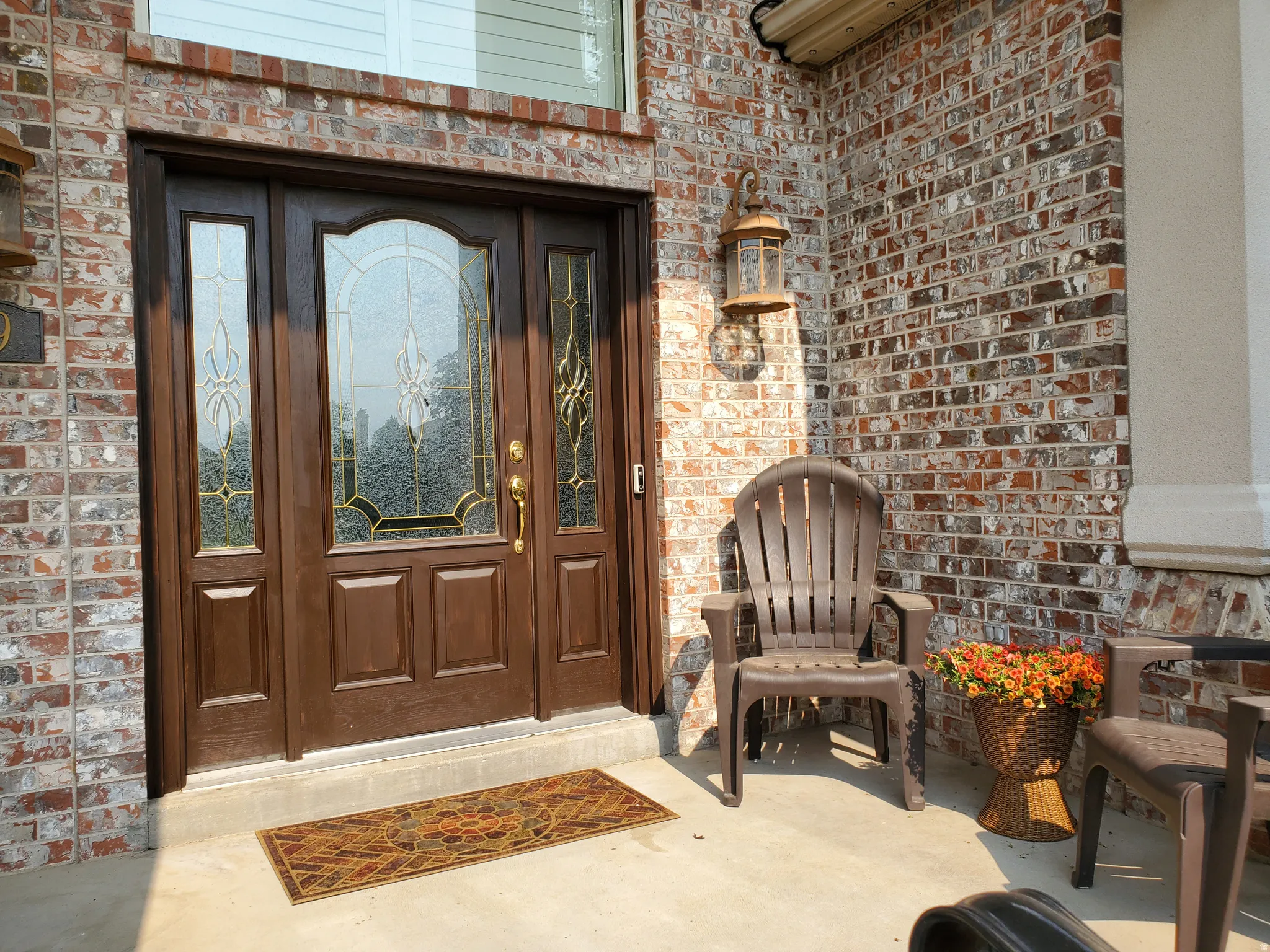 Front entry featuring a richly stained door with decorative glass side panels and transom