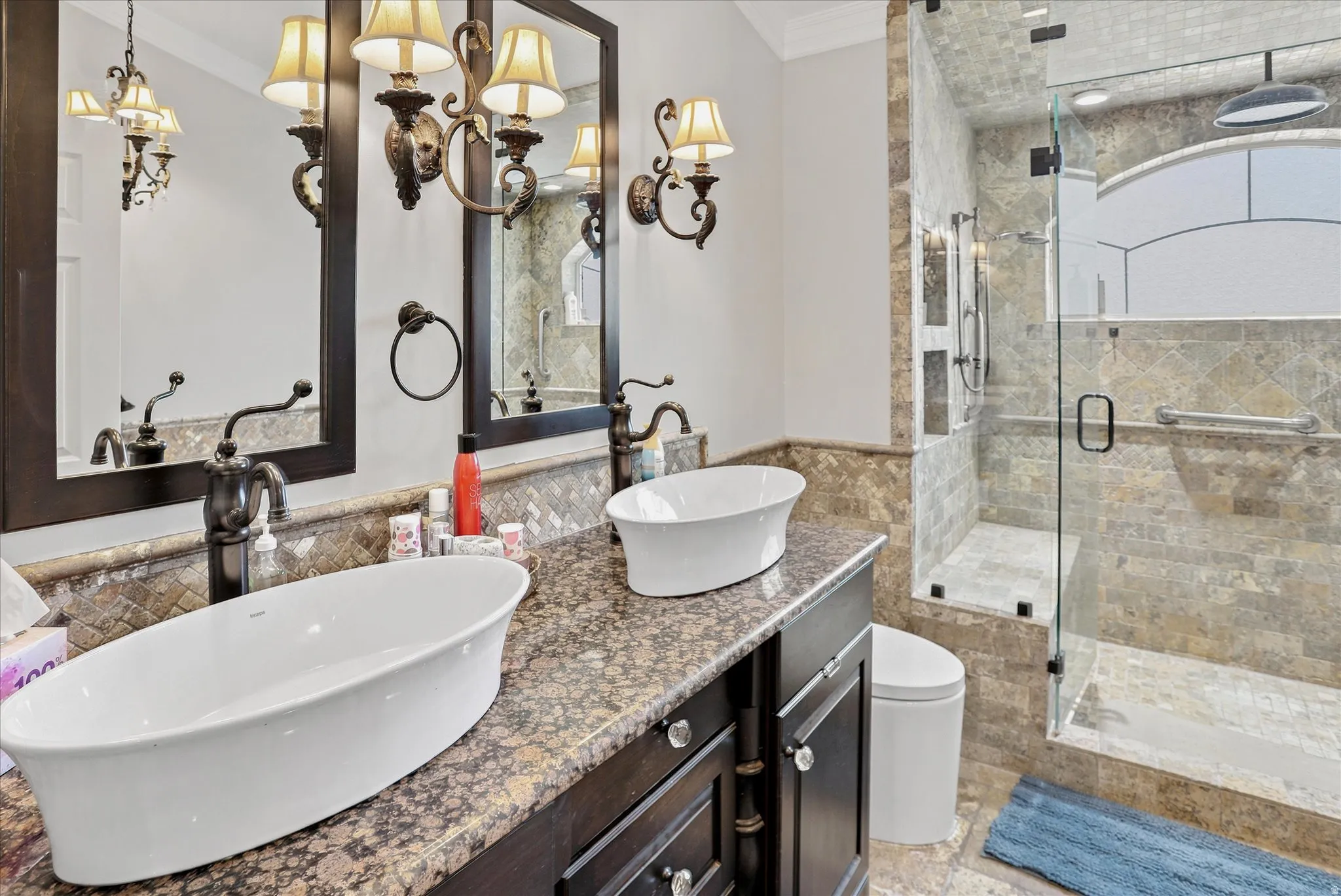 Double vanity featuring vessel sinks, dark wood cabinetry, and a speckled countertop
