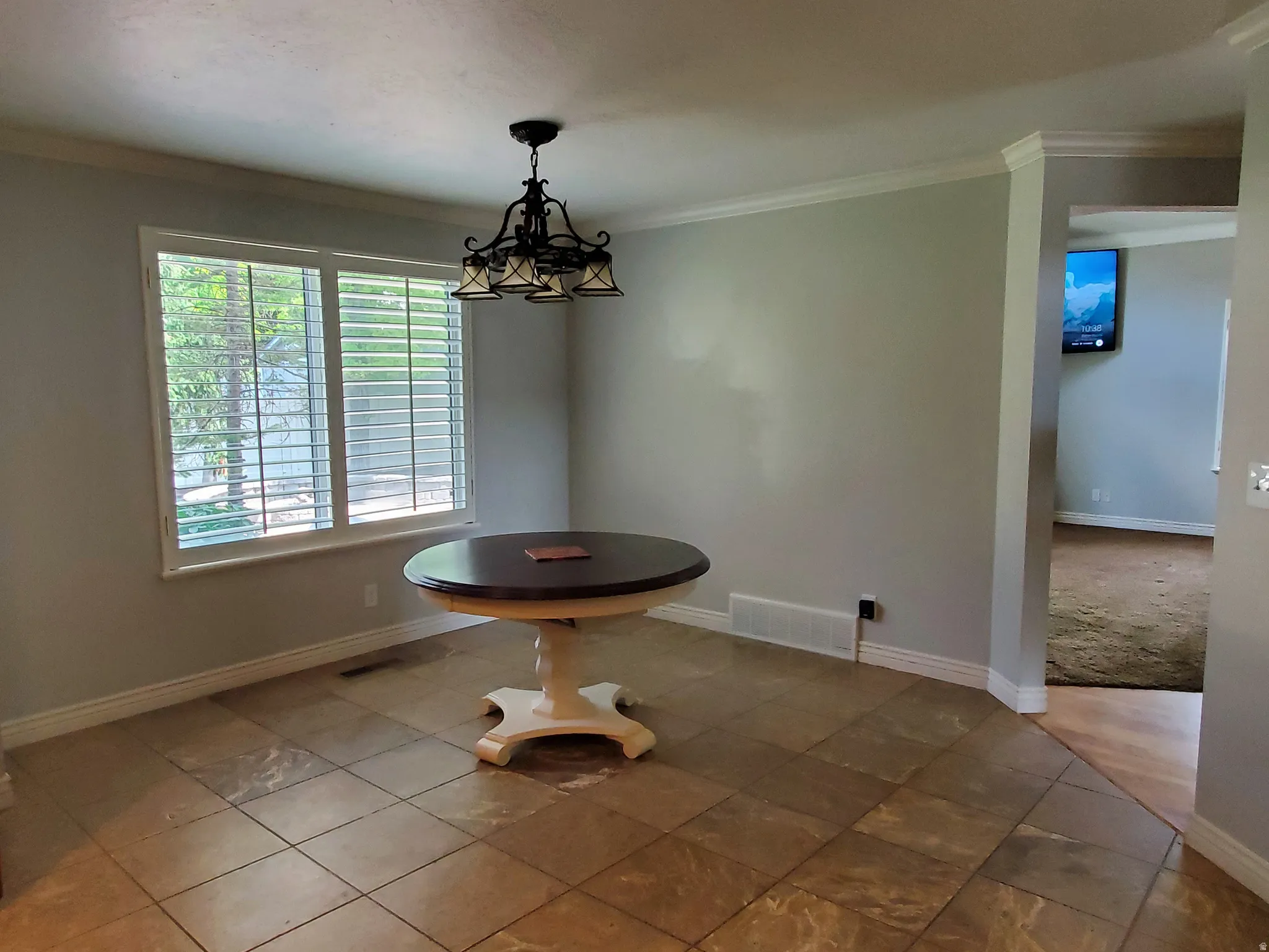 Dining area featuring large-format tile flooring and a multi-pane window with louvered blinds