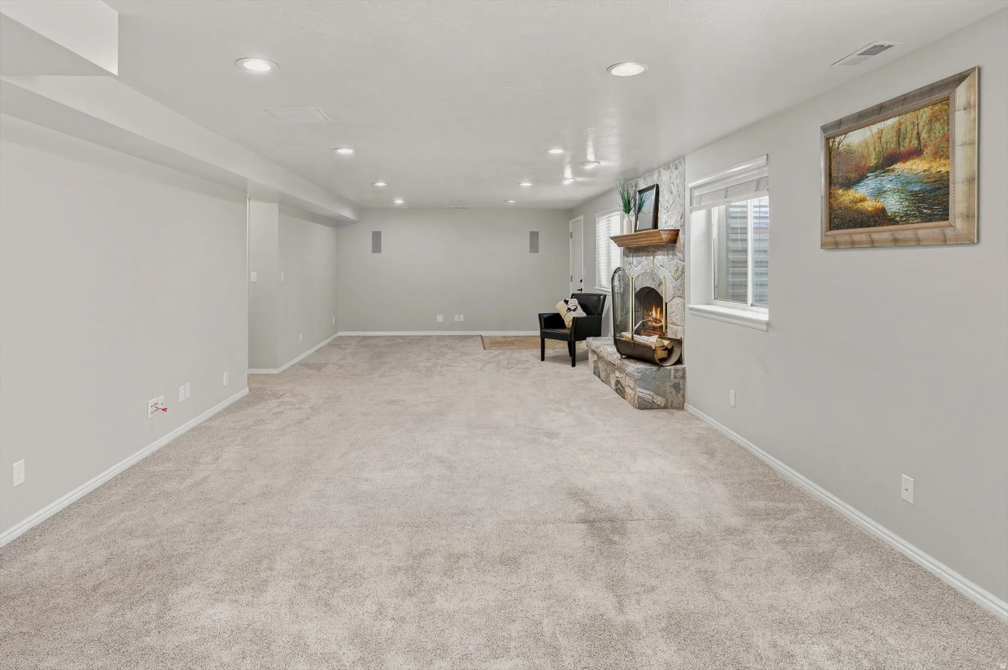 Spacious room featuring light-colored carpeting and recessed lighting
