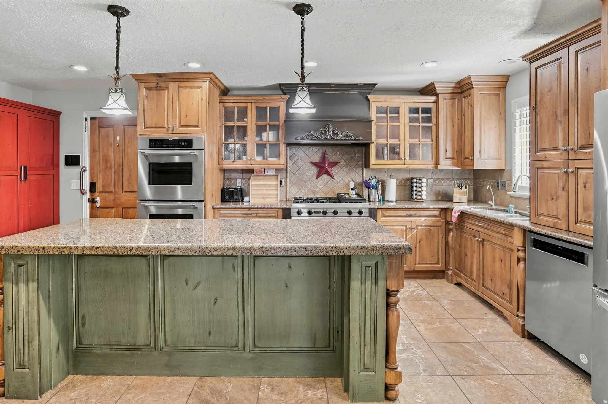 Kitchen featuring a central island with a stone countertop and distressed green paneling