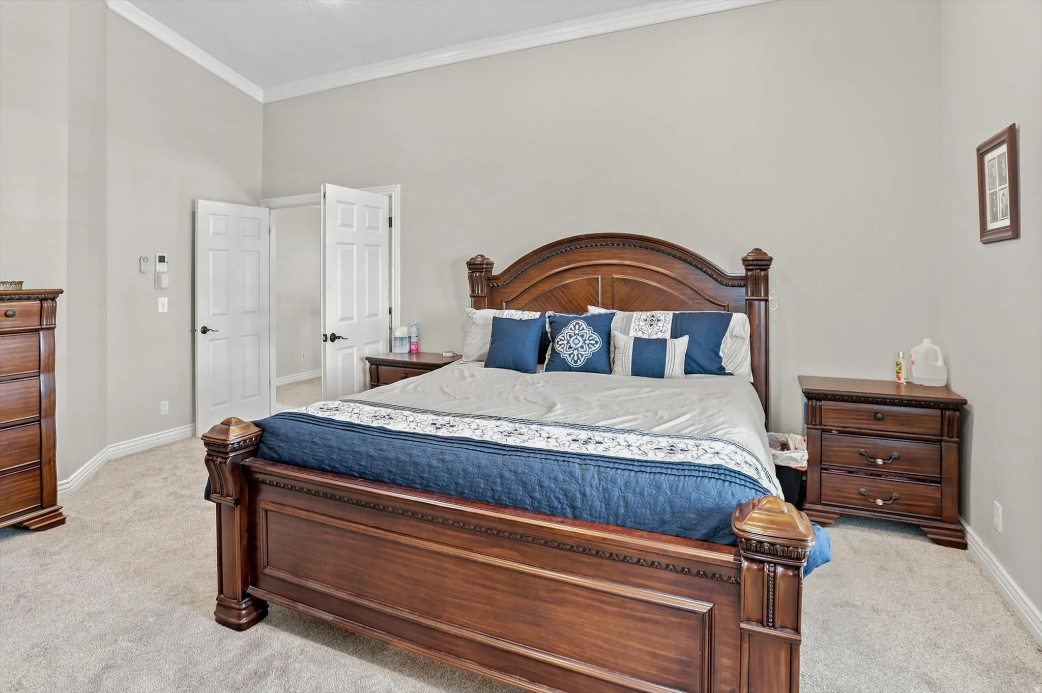 Spacious room featuring light gray walls, white crown molding, and neutral carpet flooring