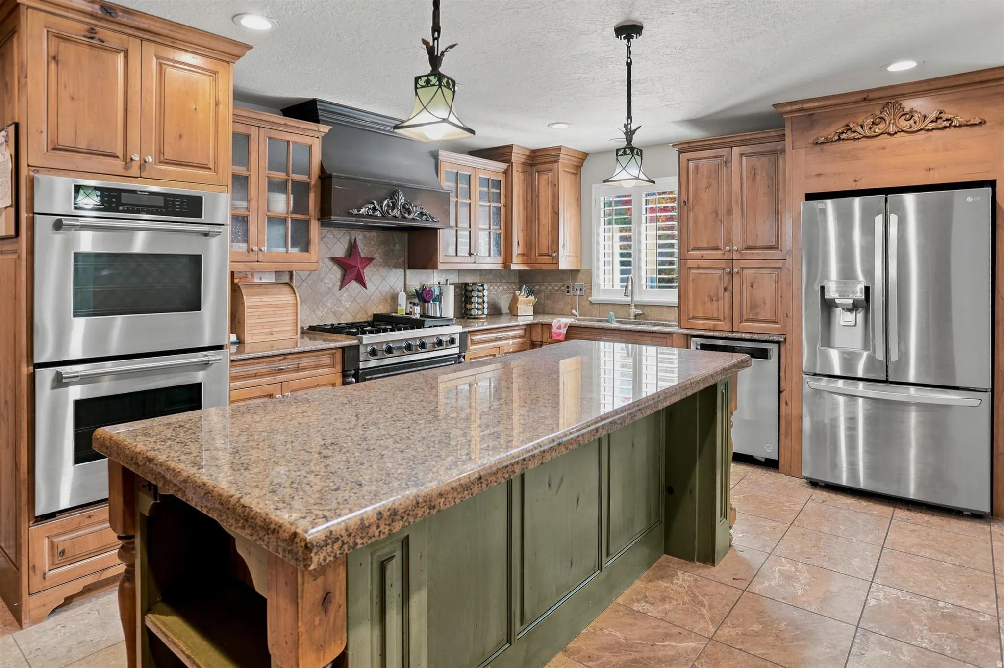 Central kitchen island with a polished granite countertop and paneled base