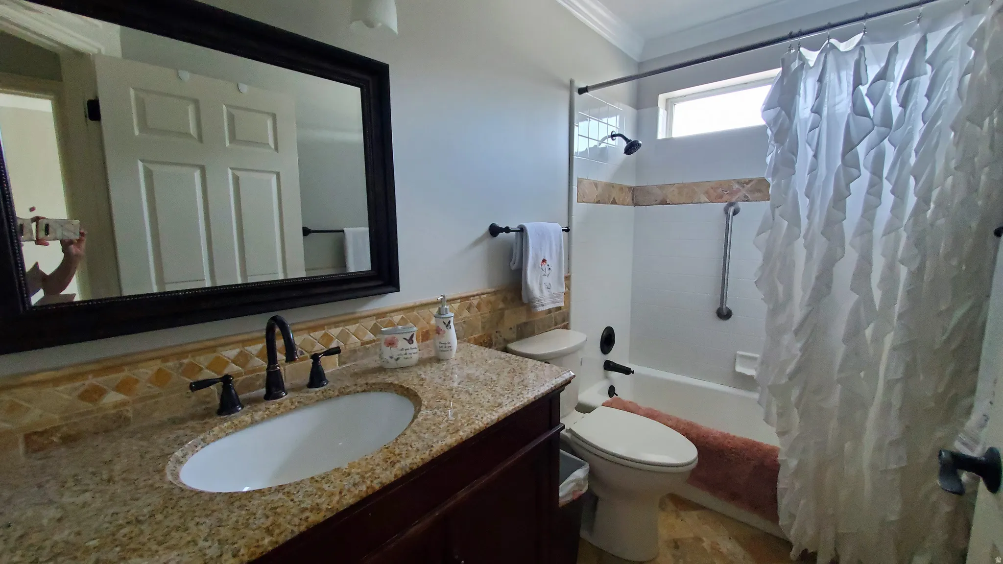 Bathroom featuring a dark wood-finish vanity with a granite countertop and an undermount sink