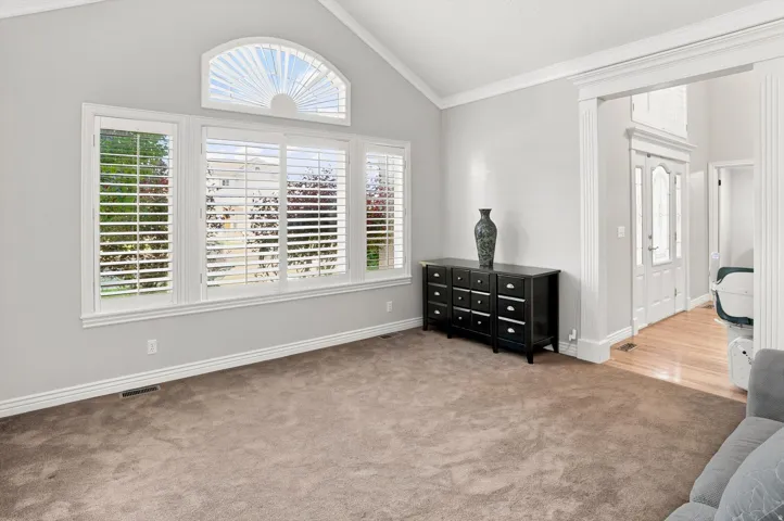 Vaulted ceiling featuring a large arched window with custom shutters