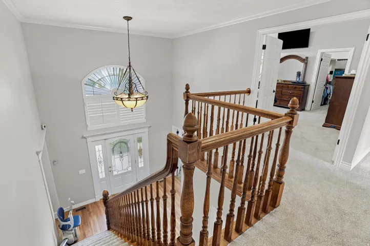 Two-story foyer with a leaded glass entry door and an arched transom window above