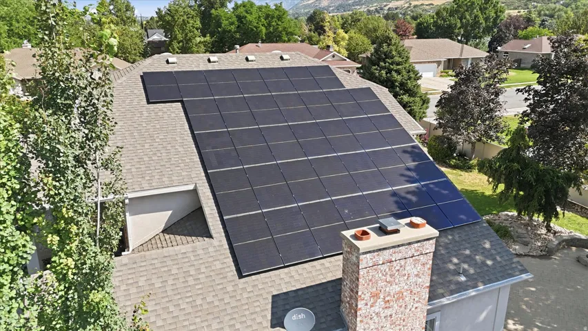 Asphalt shingle roof featuring an extensive solar panel array