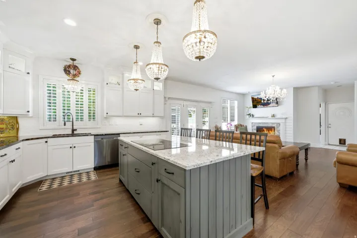 Kitchen featuring an expansive center island with seating, pendant lighting, white cabinetry, and stainless steel appliances