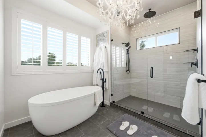 Freestanding soaking tub with a floor-mounted matte black faucet