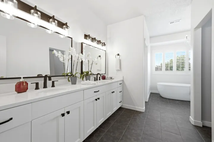 Dual vanity with white cabinetry, quartz countertops, and matte black fixtures