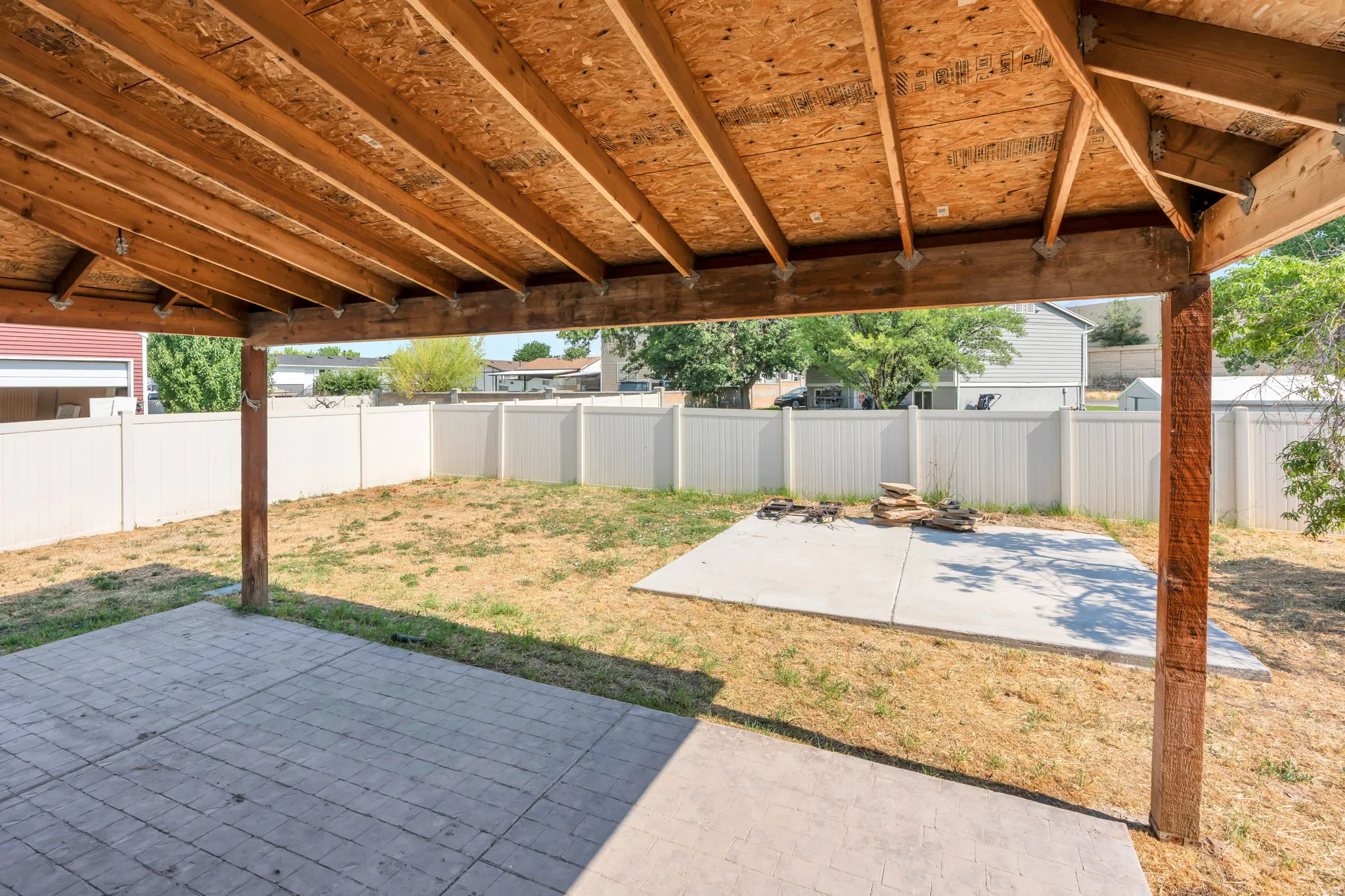 Covered patio featuring an exposed wood ceiling and structural beams