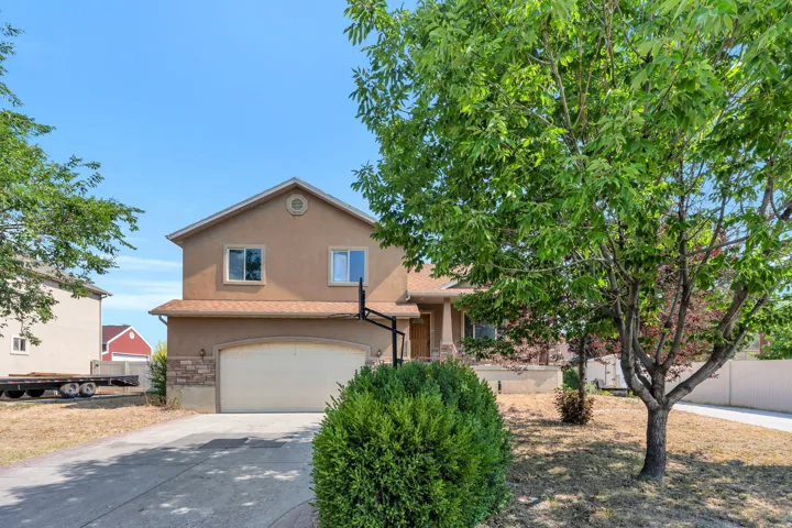Two-story stucco residence featuring an attached garage with a paved driveway