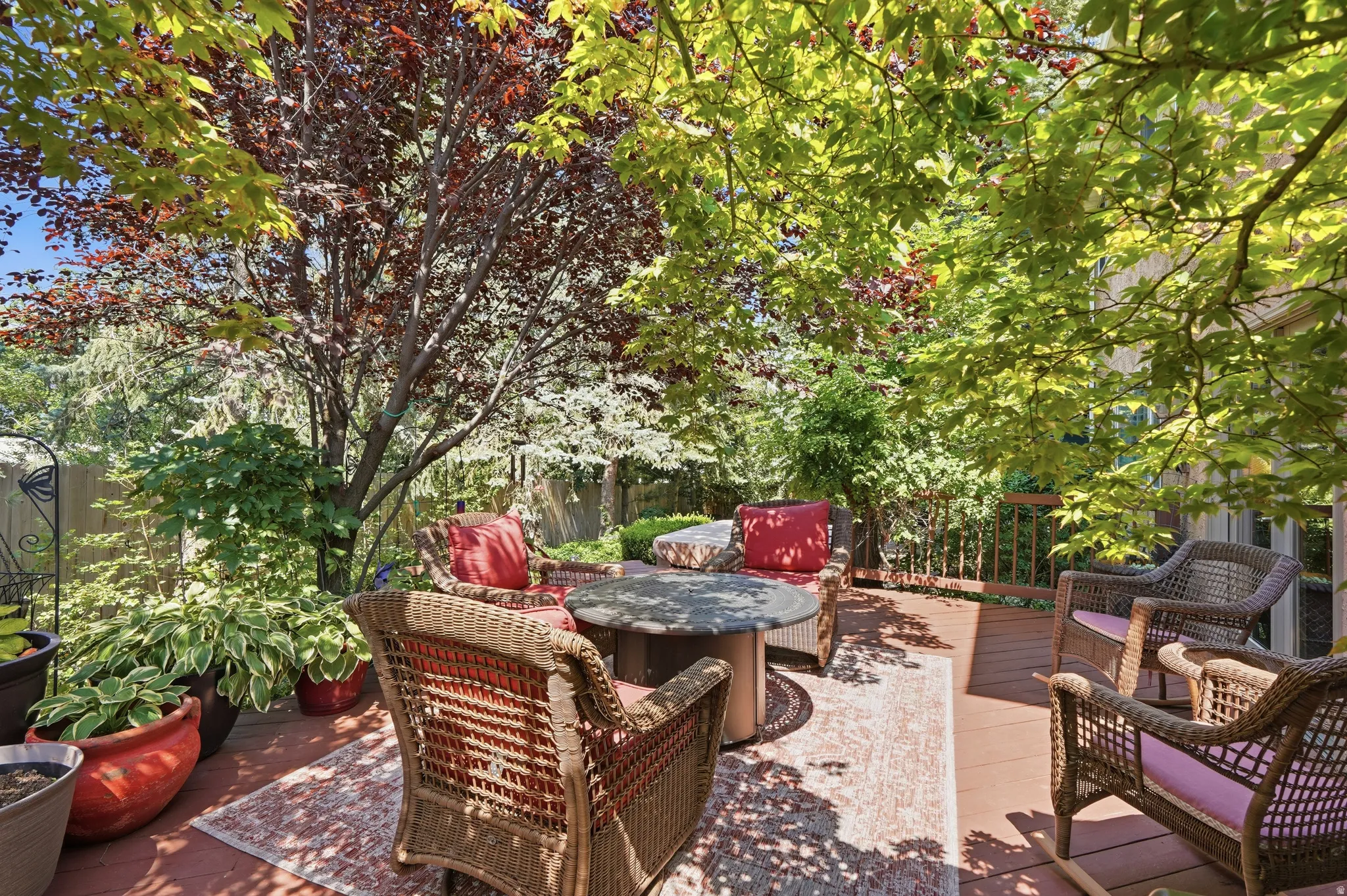 Expansive outdoor deck featuring mature trees providing natural shade