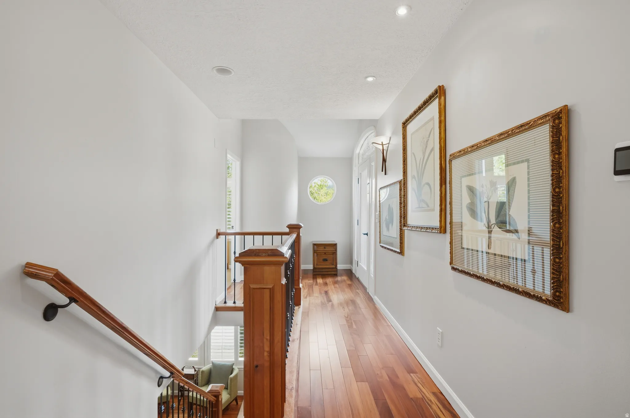 Hallway featuring wood-finish flooring, recessed lighting, and cute roumd window