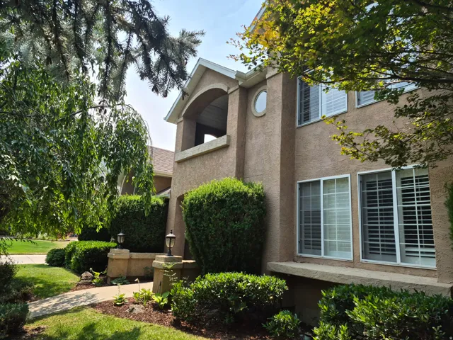 Stucco exterior featuring an arched balcony and a circular accent window