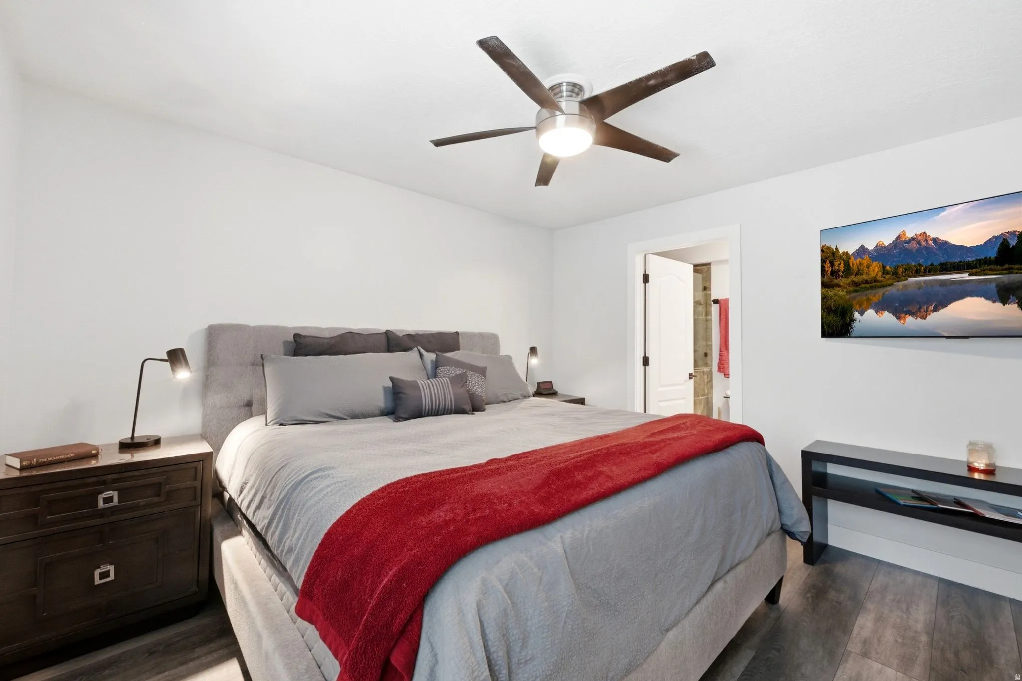 Bedroom featuring wood-finish flooring, a contemporary ceiling fan, and a wall-mounted television